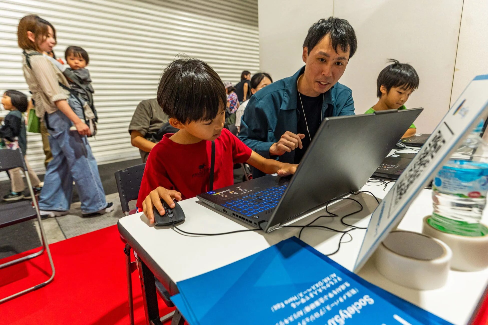 親が子供にPC操作を教える様子