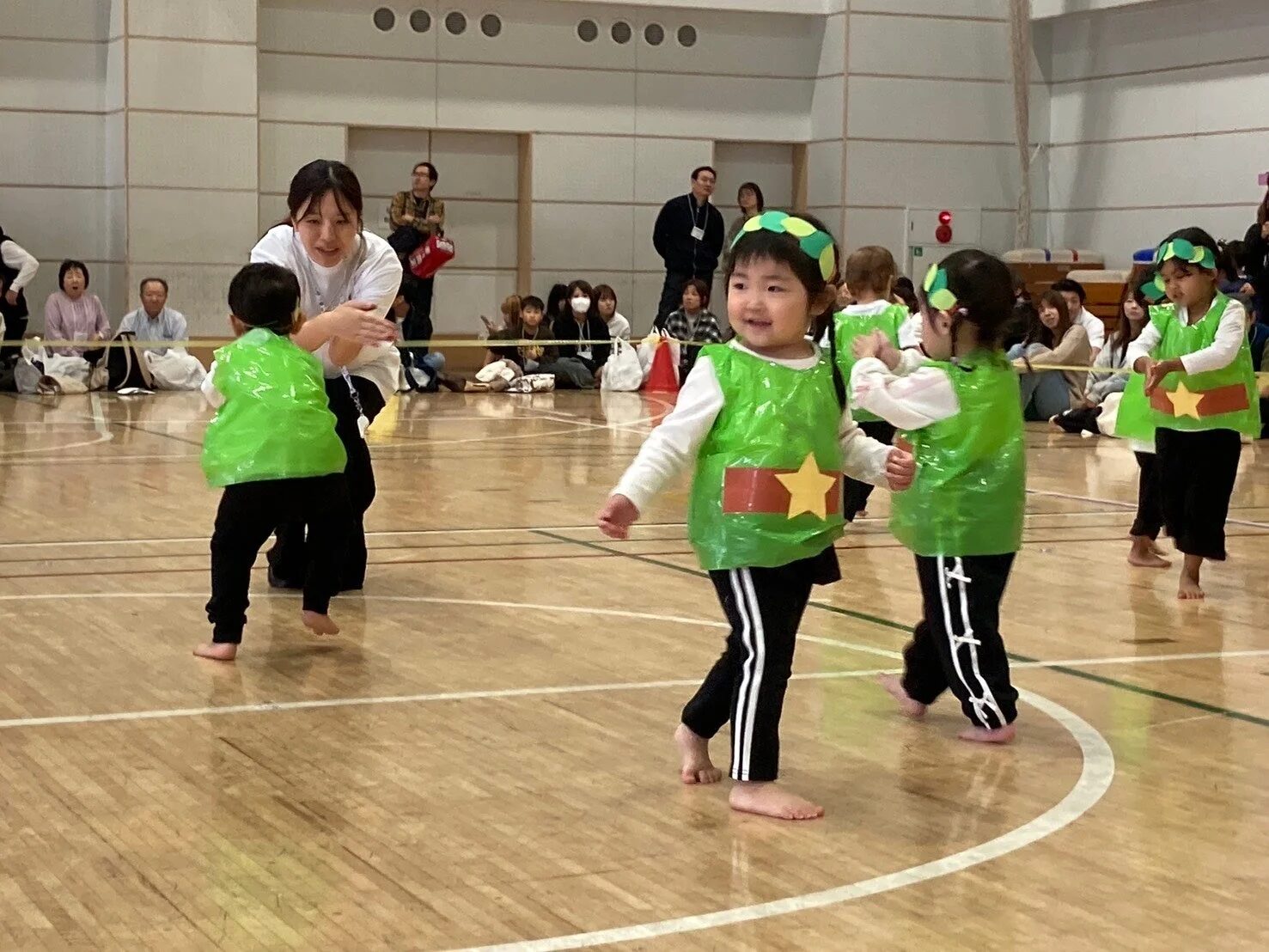緑色の衣装でダンスをする幼児たち