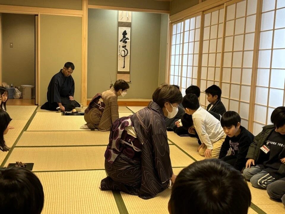 和室で茶道体験をする大人と子供たち