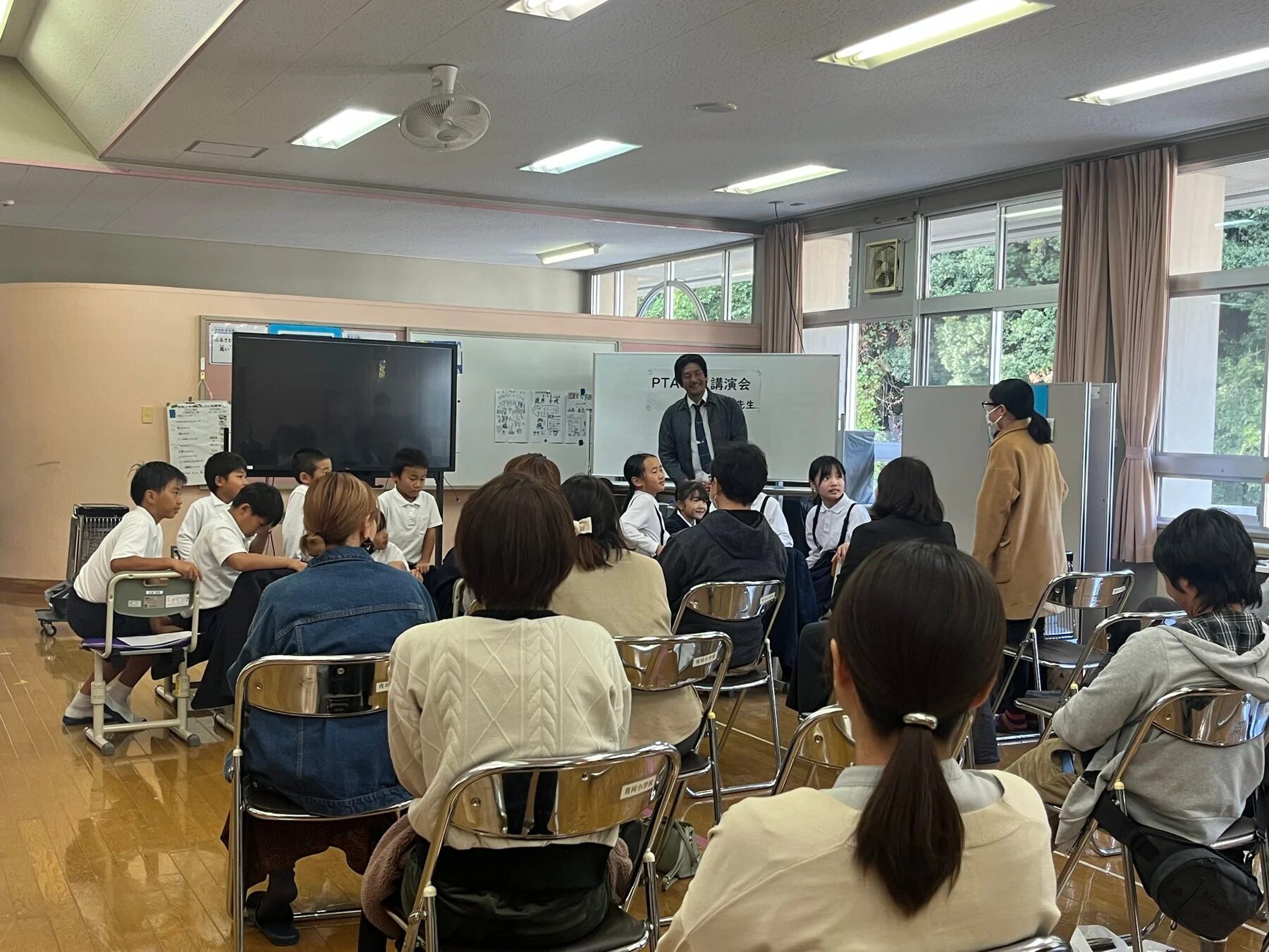 報告会に参加する保護者と地域住民