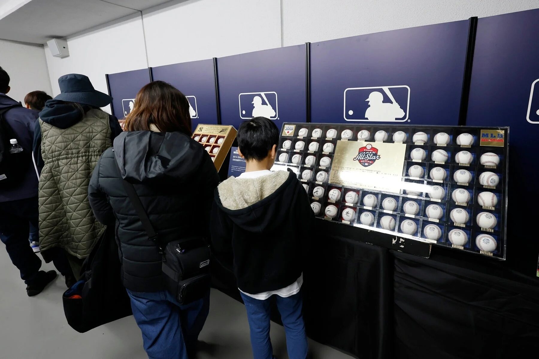 MLBミュージアムでサインボールを見る親子