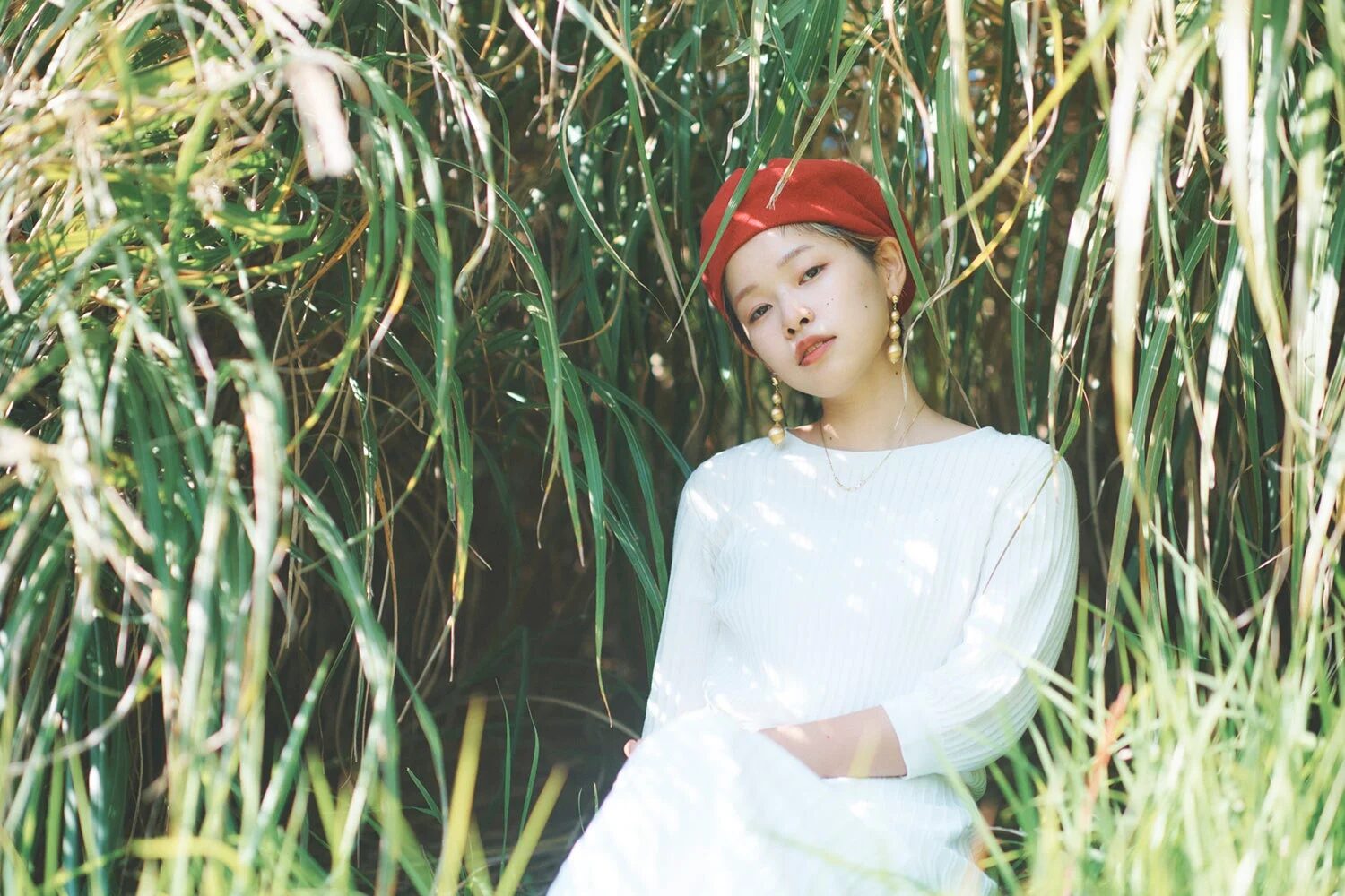 赤いベレー帽と白い服を着た若い女性のポートレート写真