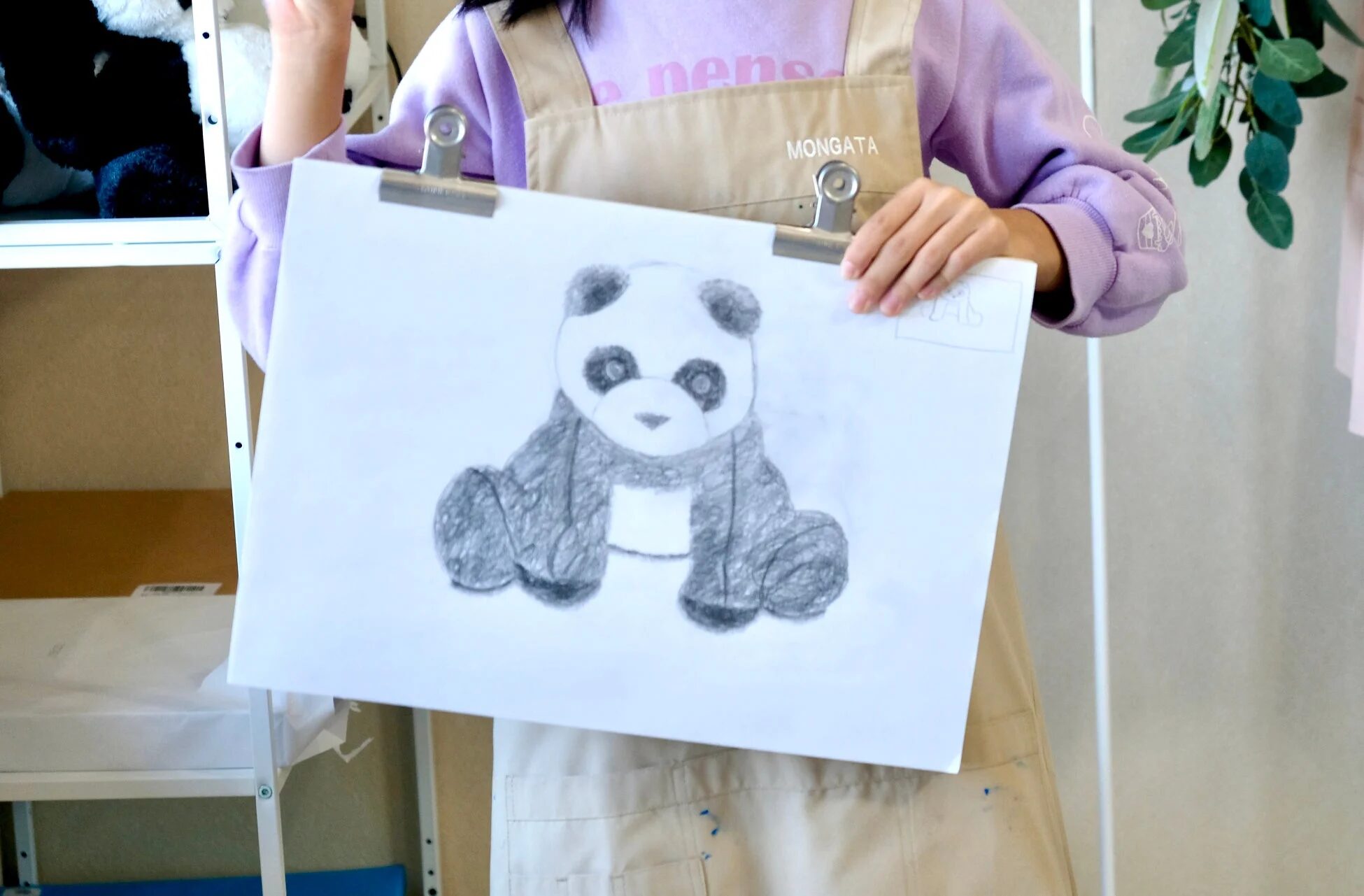 パンダのデッサンを持つ人物