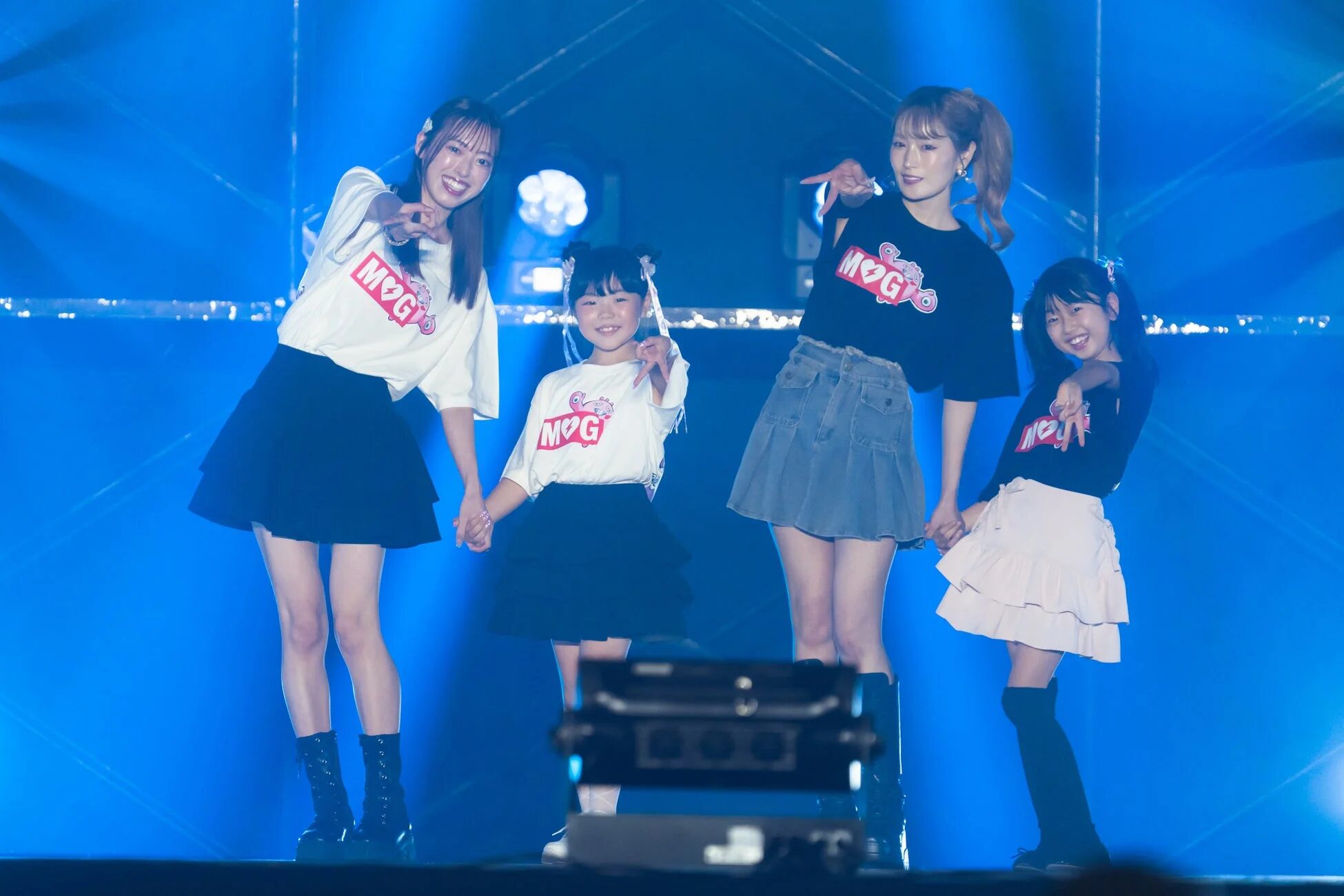 ステージでポーズをとるアイドルと子供たち