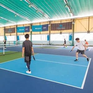 屋内コートで複数の人々がピックルボールを楽しんでいる様子