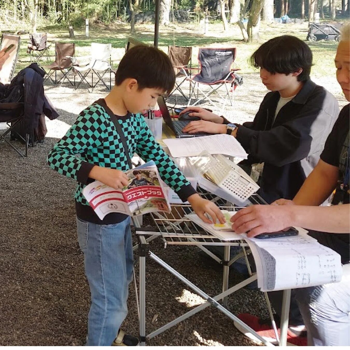 屋外でノートパソコンを囲む子どもたち