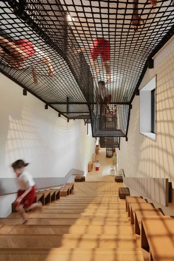 ネットの遊び場で遊ぶ子供たちと木製の階段