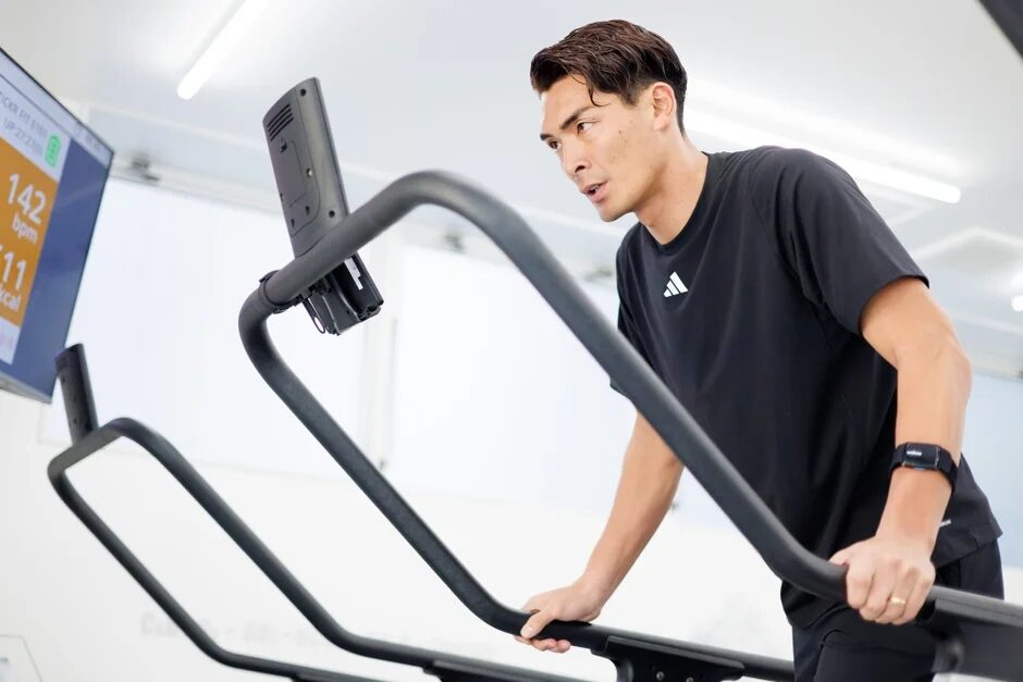 ジムで男性がフィットネス機器を使ってトレーニングしている様子