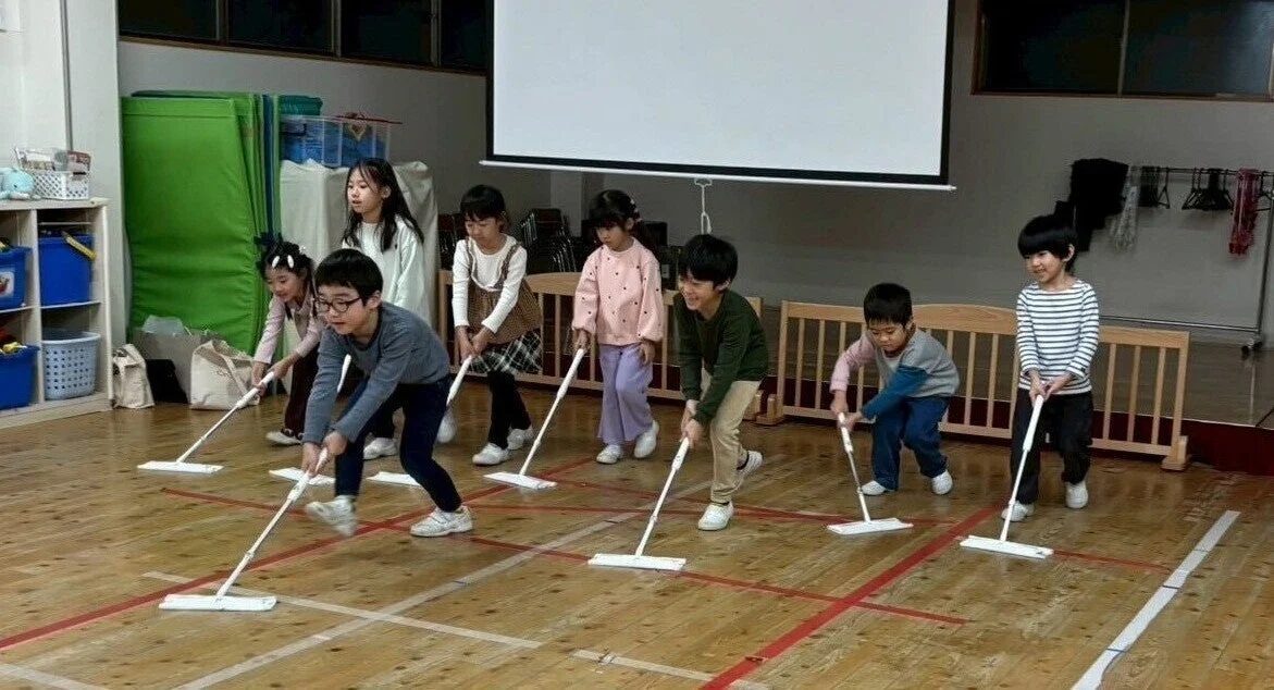 子供たちがモップで床掃除