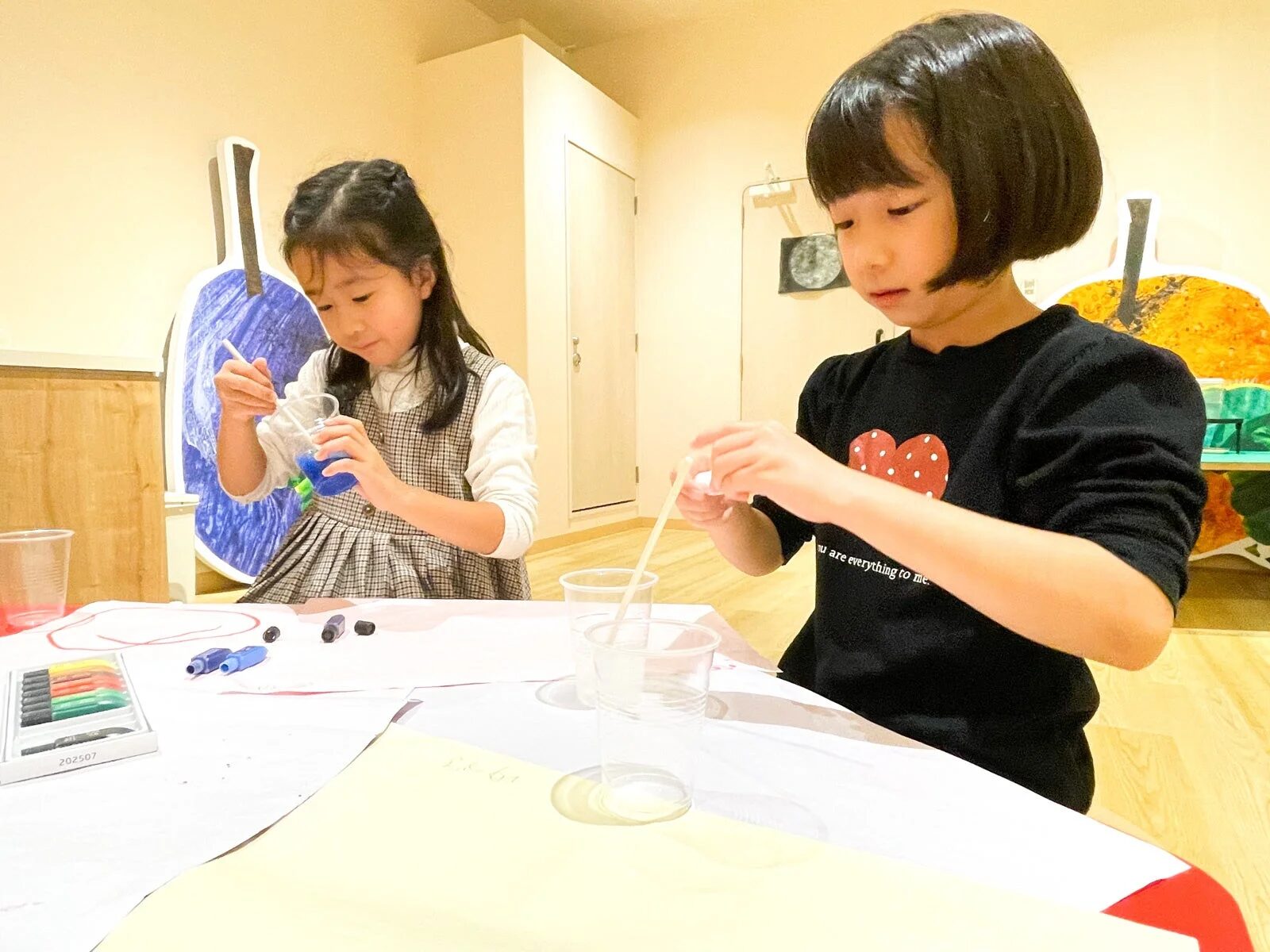 色を混ぜてアート活動に集中する二人の幼い女の子