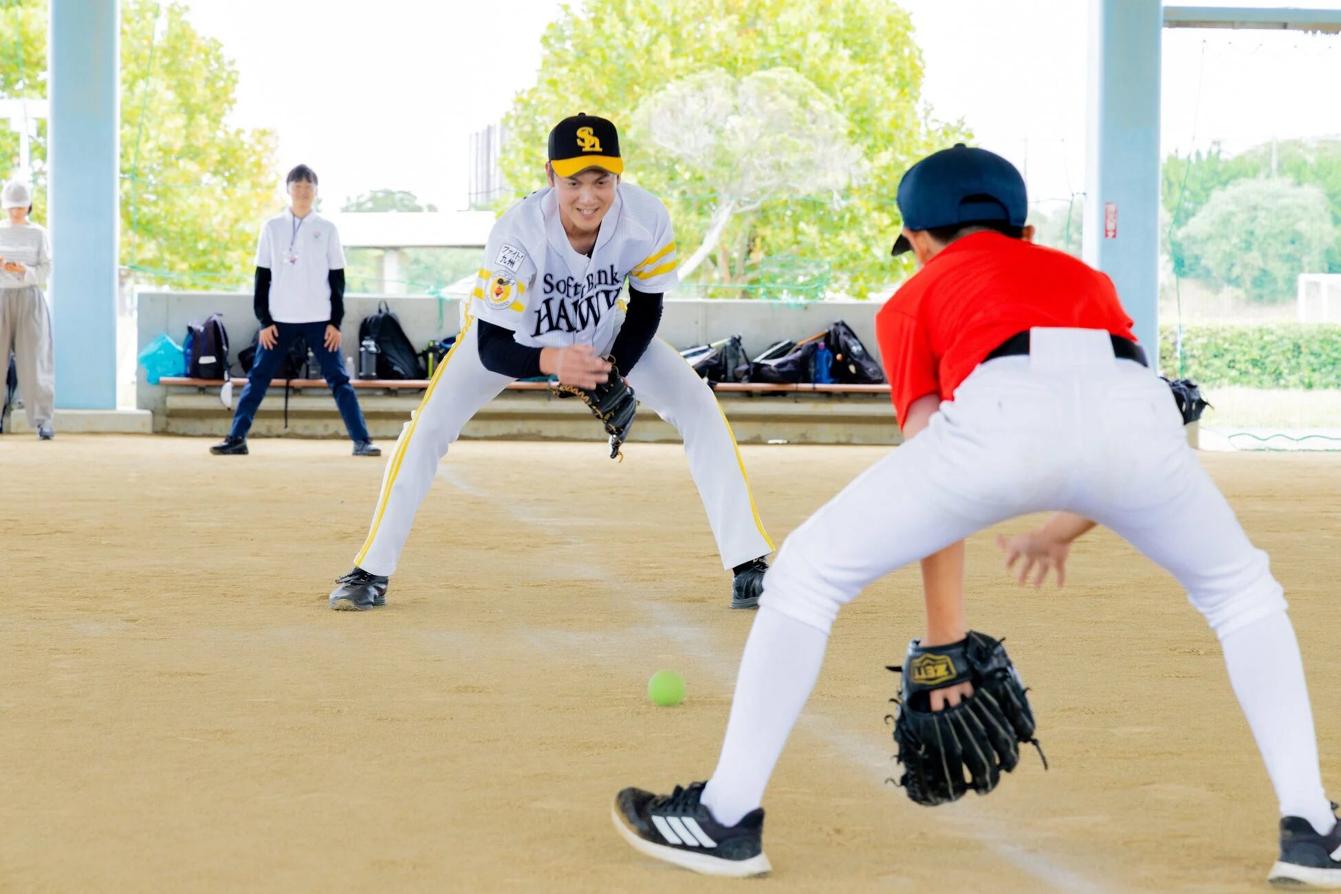 キャッチボールをする子供たちとコーチ