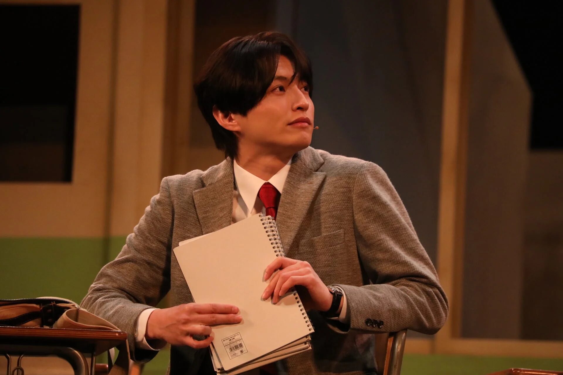 真剣な表情でノートを見つめる教師役の小南光司さん