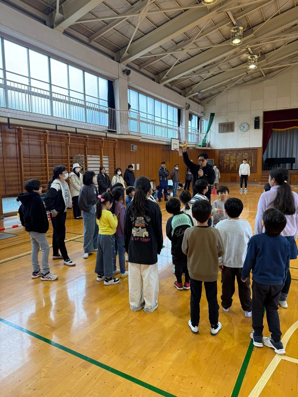体育館で講師の話を聞く子供たち