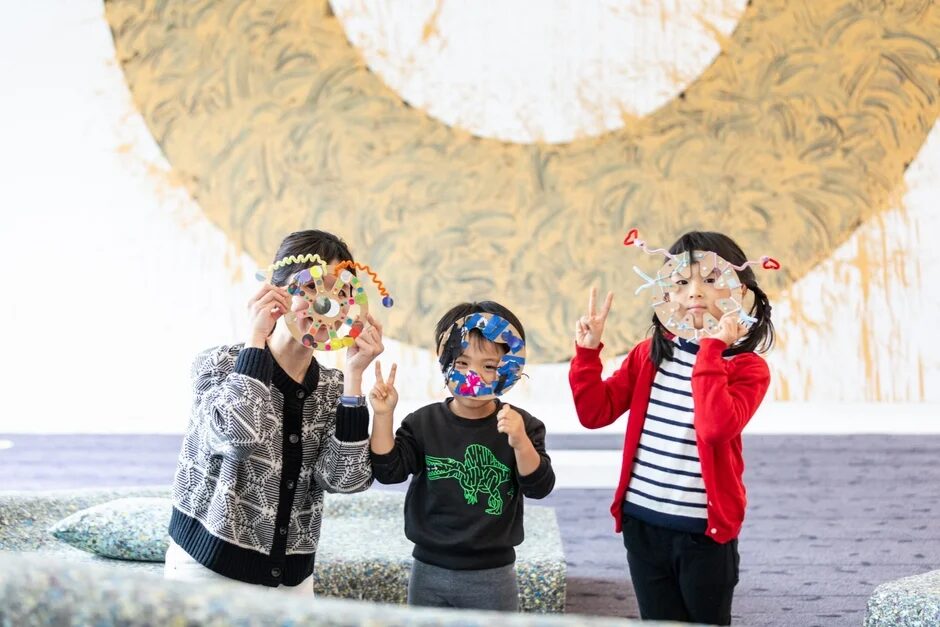 家族が手作りマスクを顔にかざす様子