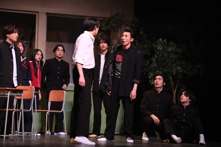 教室で演劇を行う学生服姿の若者たち