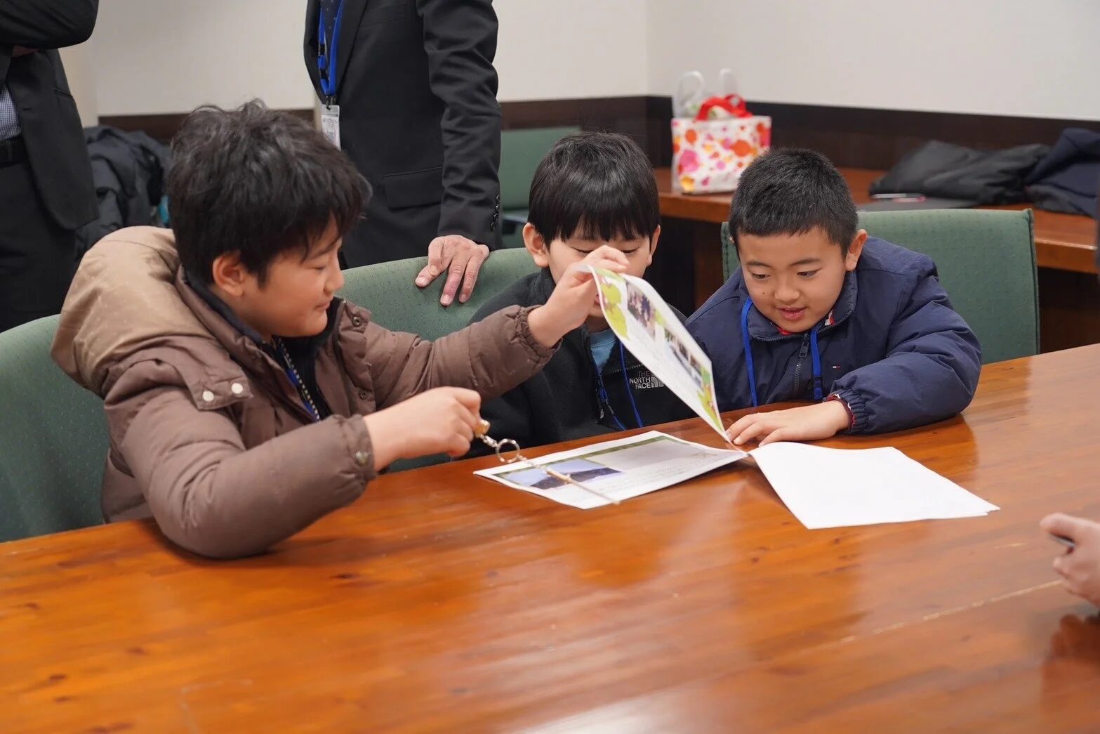 テーブルで資料を見ながら議論する子どもたち