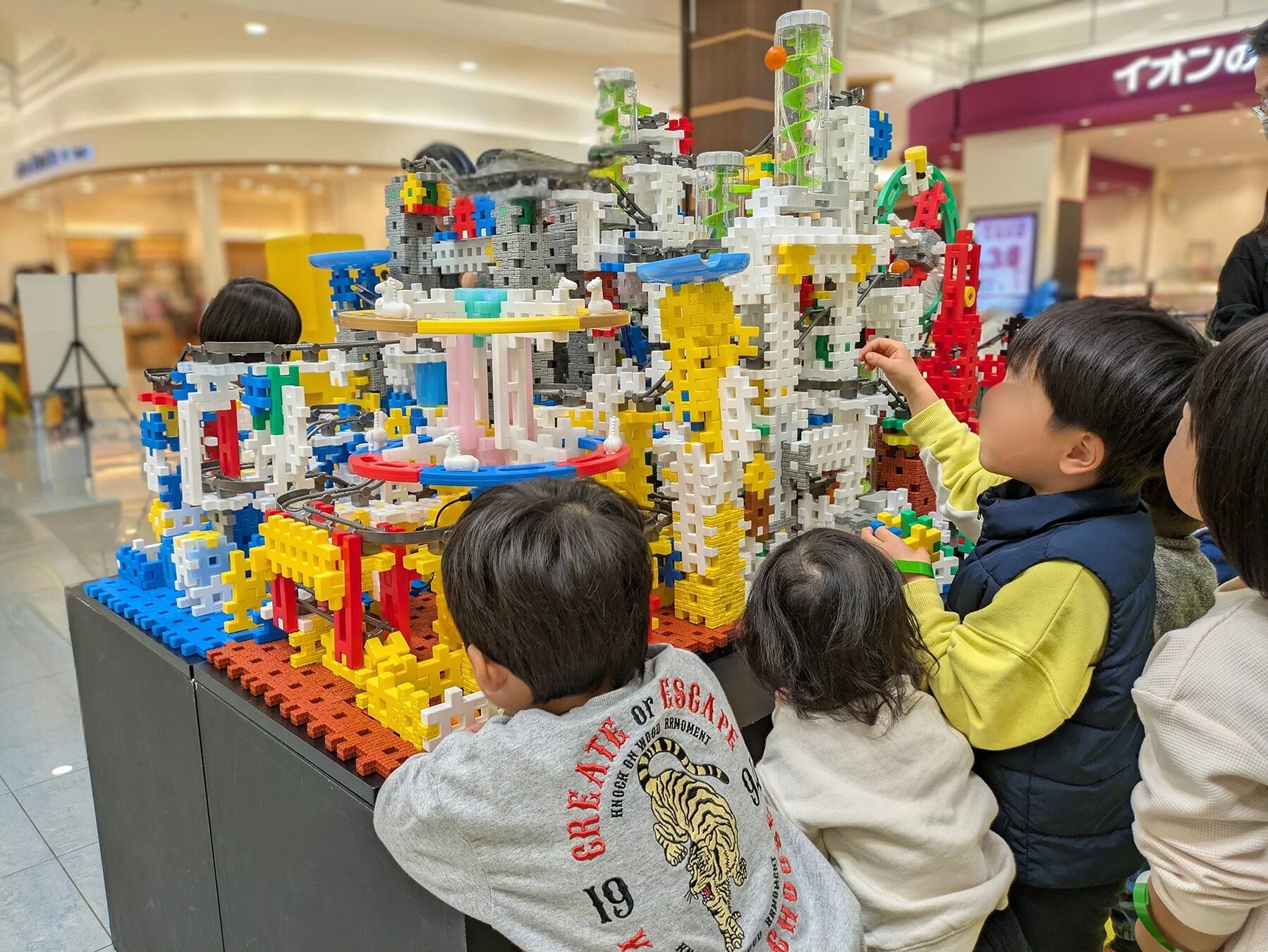多くの親子連れがブロック玩具で遊ぶ様子