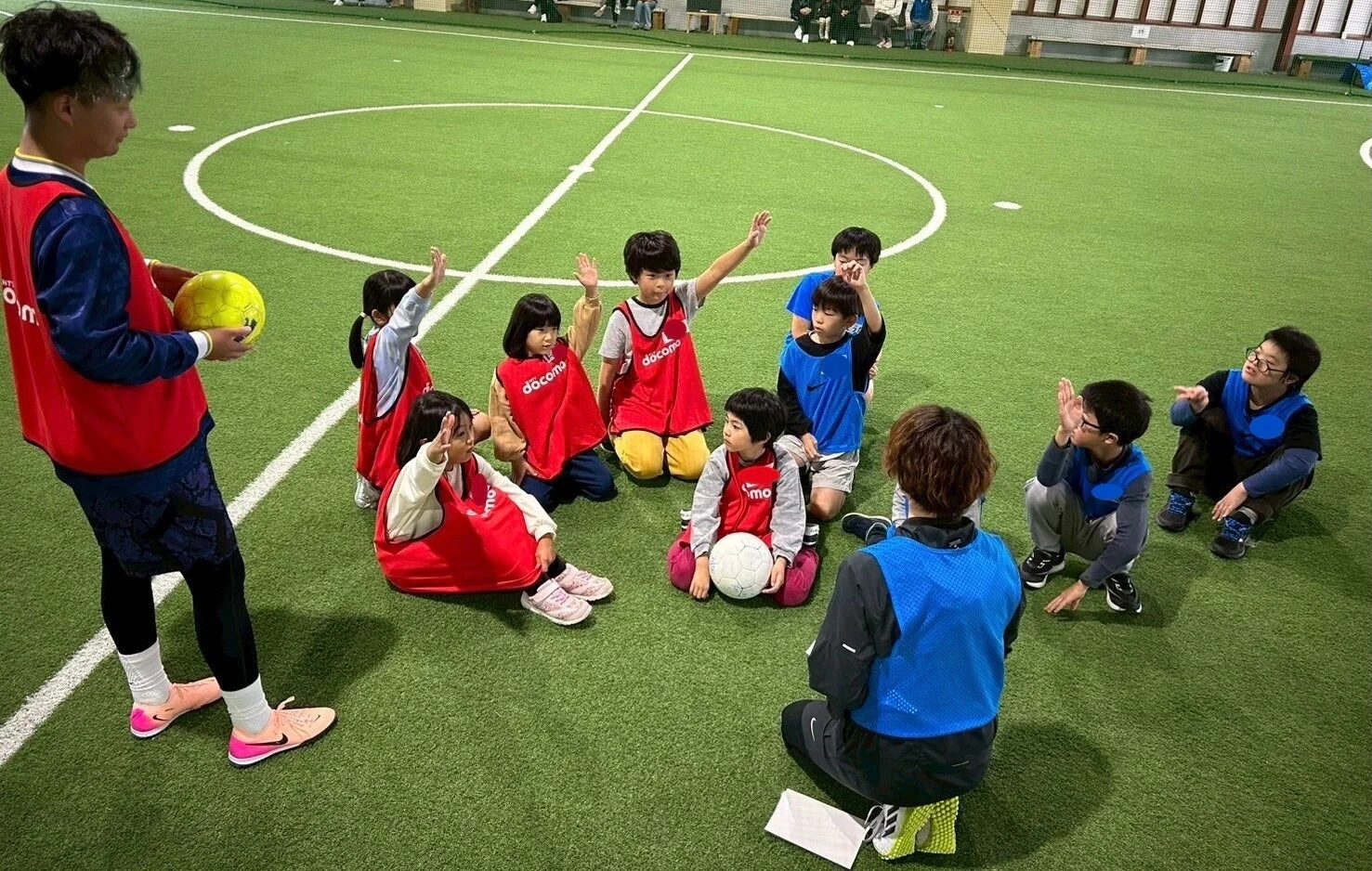 コーチの説明を聞く子供たち