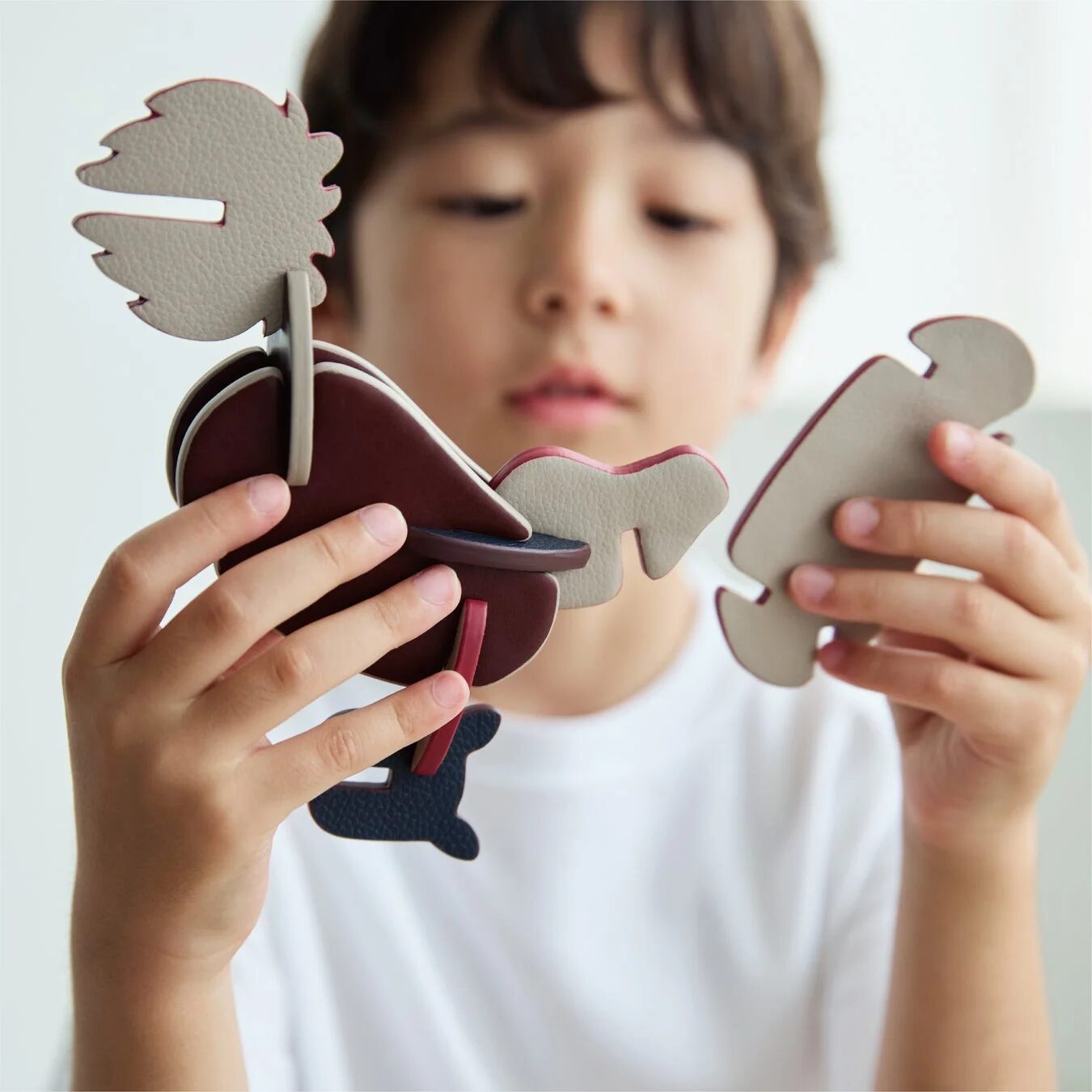 子供が革製パズルを組み立てる様子