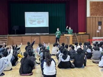 体育館で多くの生徒が参加する食育の授業風景