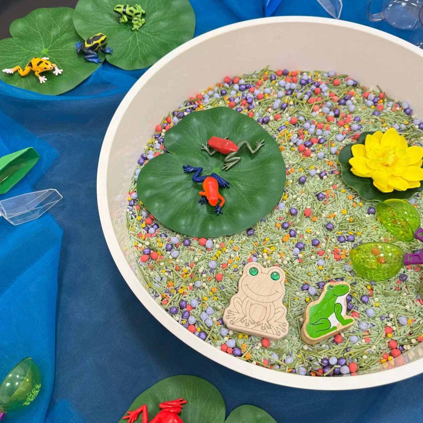 カエルのおもちゃと睡蓮の葉が配置されたセンサリービン