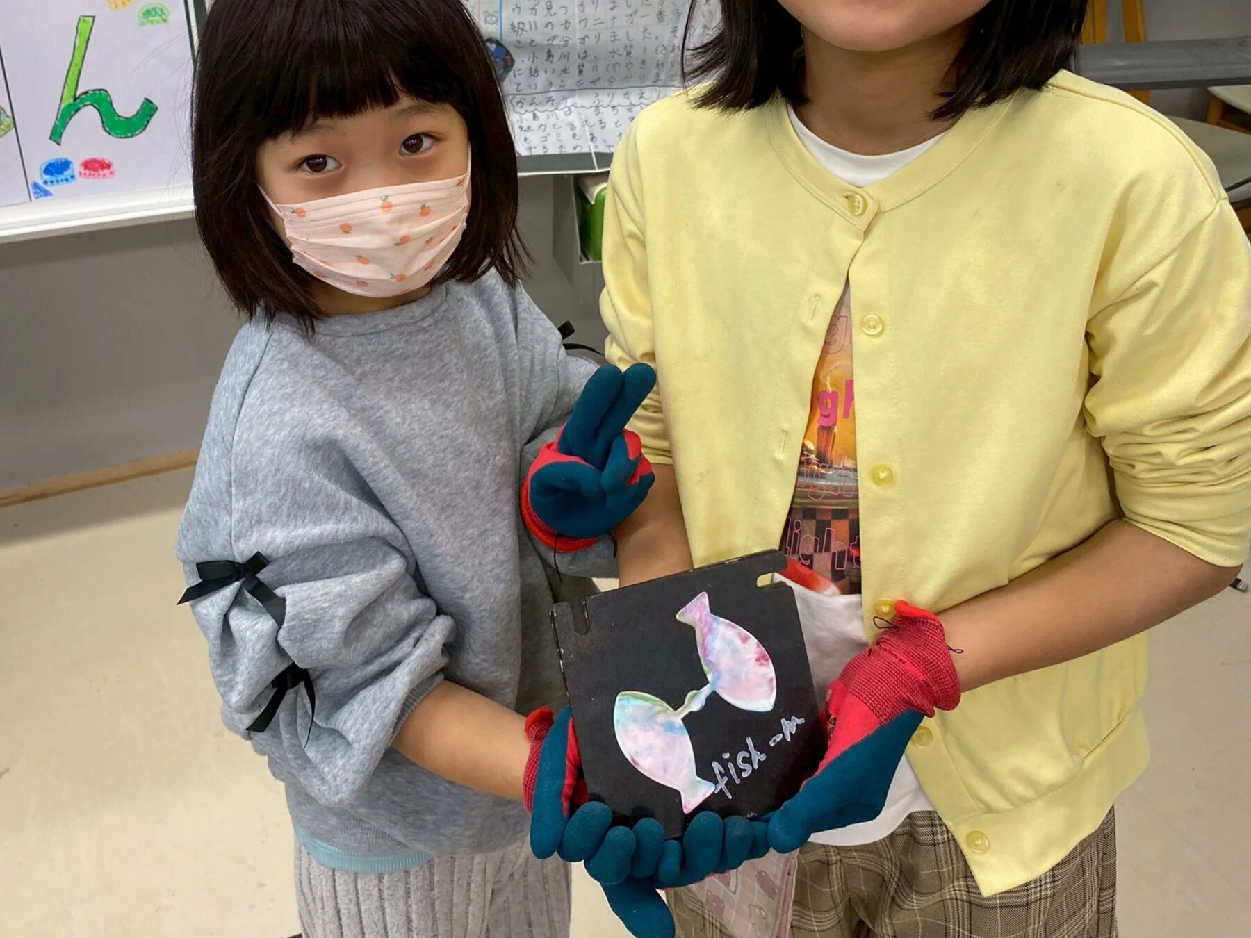 魚の工作品を持つ子どもたち