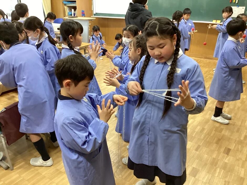 あやとりやけん玉をする子供たち