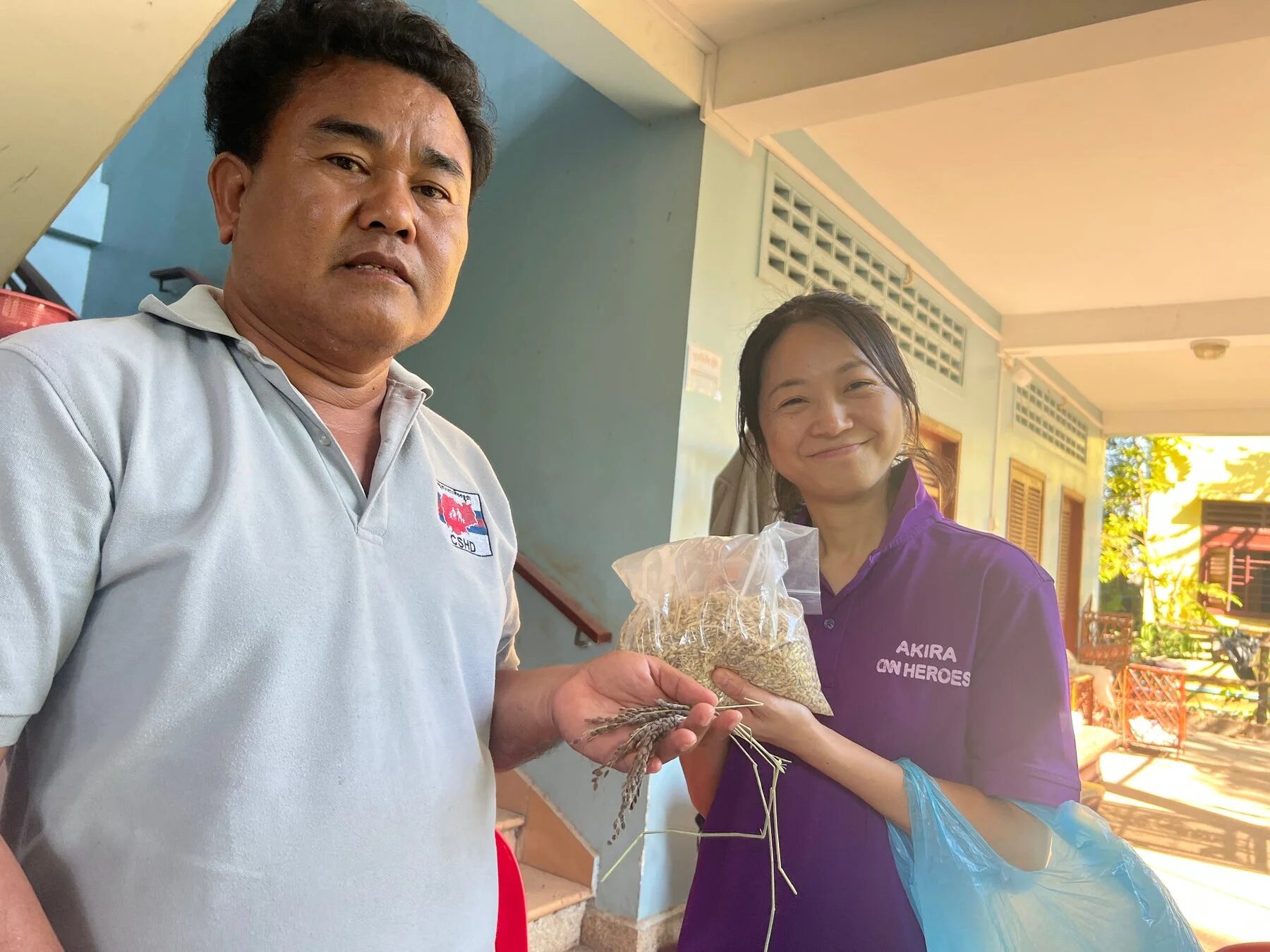 稲穂と米を持つ人々