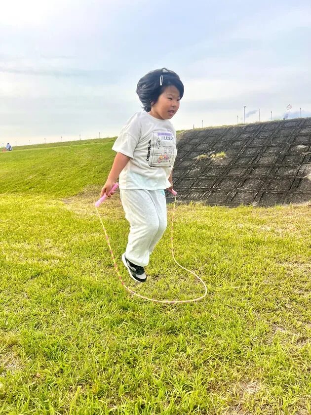 草原で縄跳びをする女の子