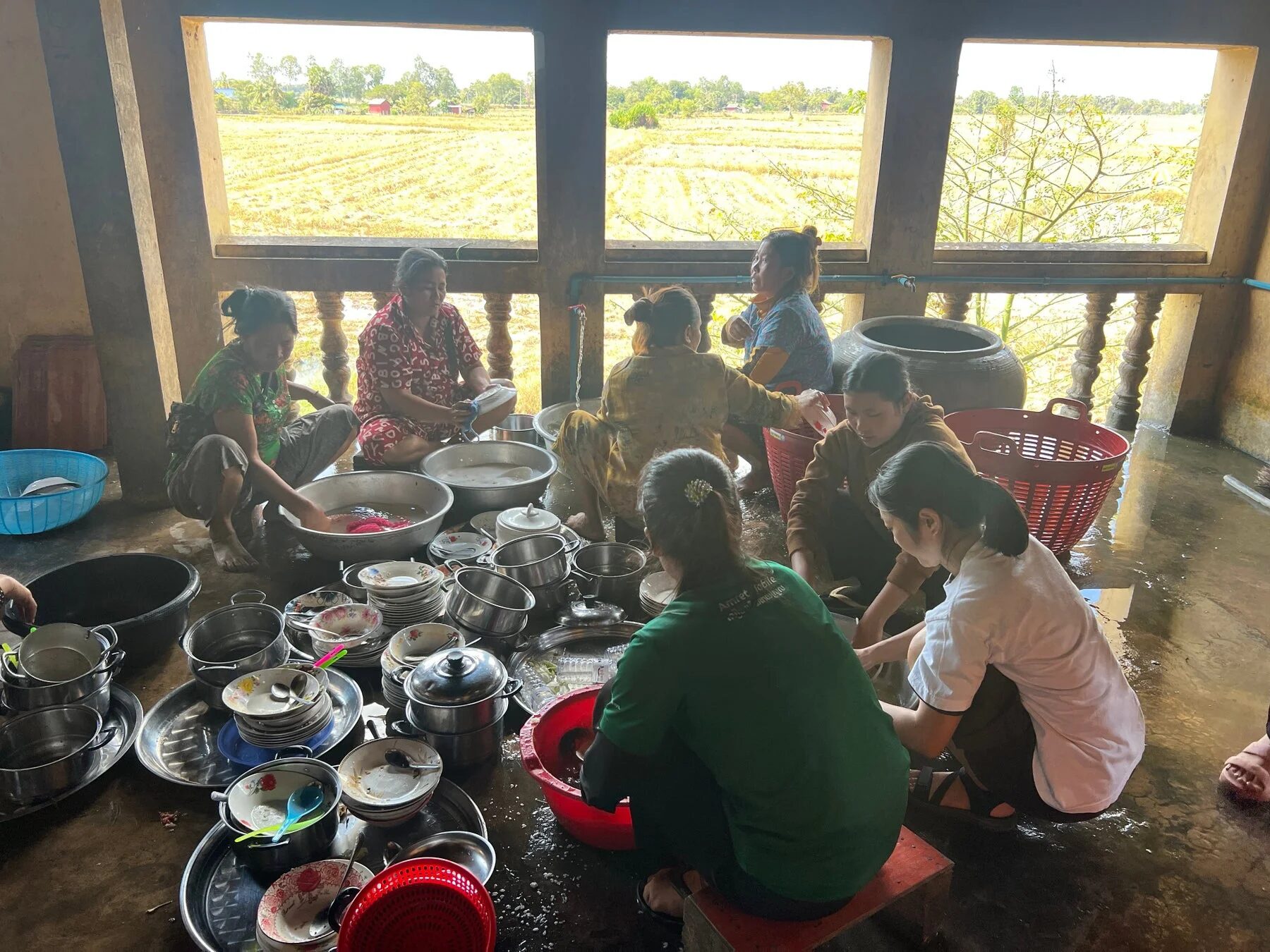 屋外で食器洗いをする女性たち