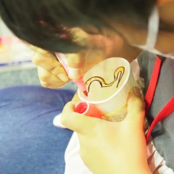 紙コップに絵を描く様子