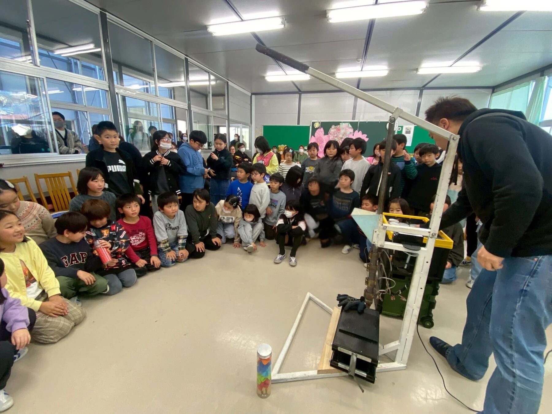 機械のデモンストレーションを見る子どもたち